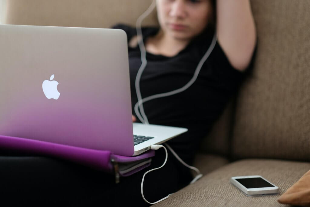 Young person using laptop on sofa