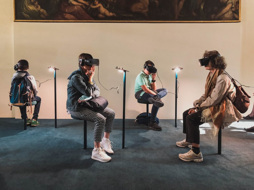 Adults and young people using Virtual Reality headsets in a wide, spacious room.