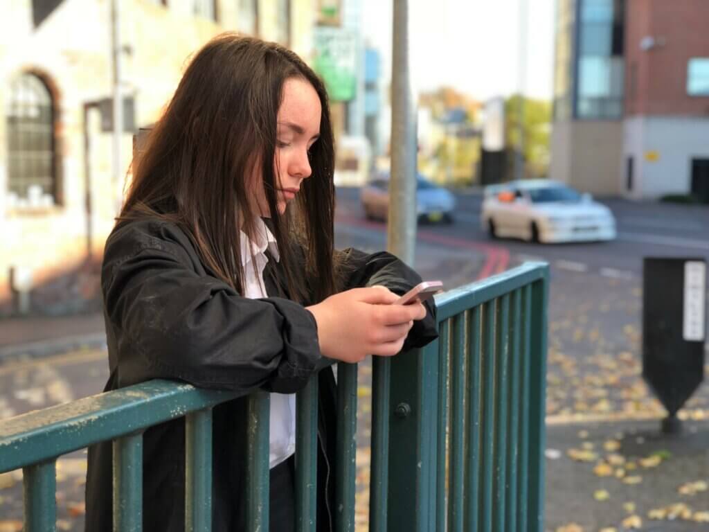 Teenage girl stood outside on mobile phone